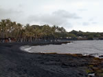 black sand beach across from boat shed